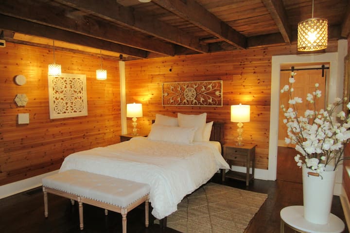 ห้องนอน 1: ห้องนอนควีนไซส์ที่มีเสน่ห์แบบชนบทชั้นแรกมีคานดั้งเดิมพร้อมประตูโรงนาเพื่อความเป็นส่วนตัว