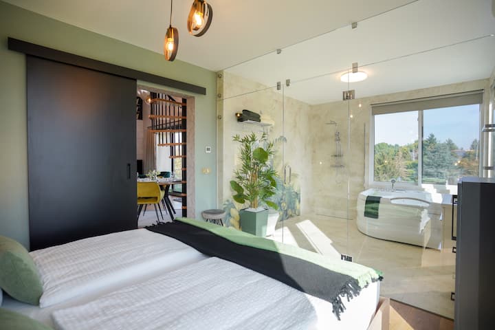 ห้องดอกไม้สีเขียวแยกจากห้องน้ำพร้อมอ่างแชมเปญ