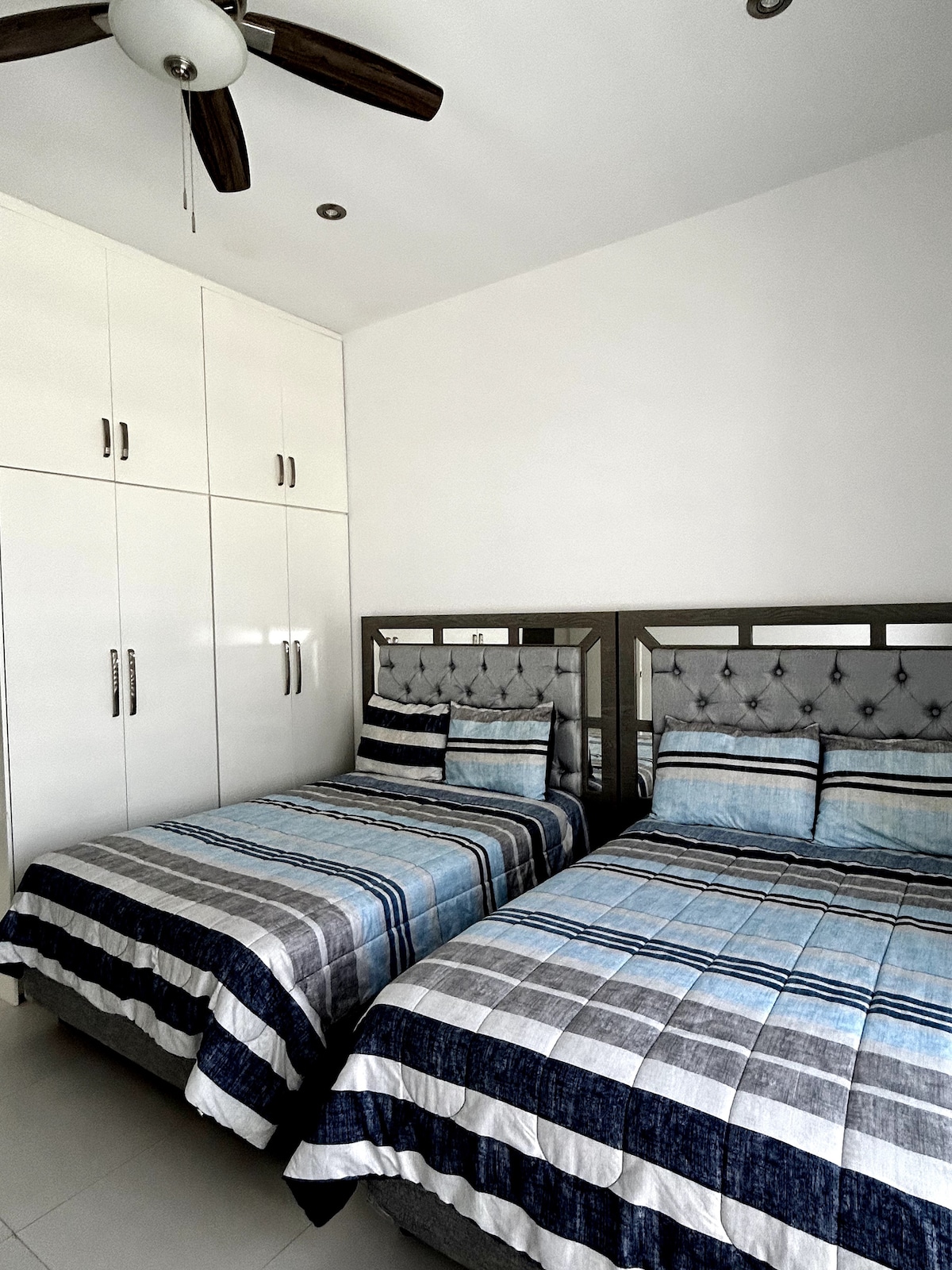 Recámara 2: Habitación con dos camas matrimoniales, baño completo y armario.