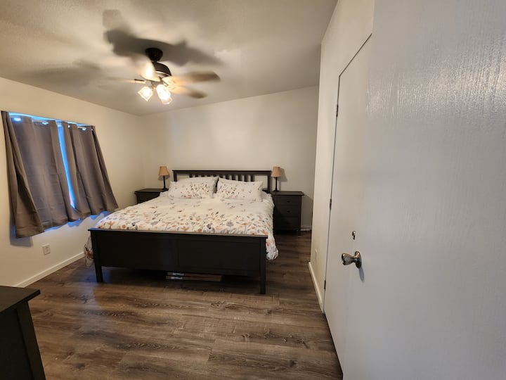 Dormitorio principal con una cama tamaño king, un baño completo y un armario grande.