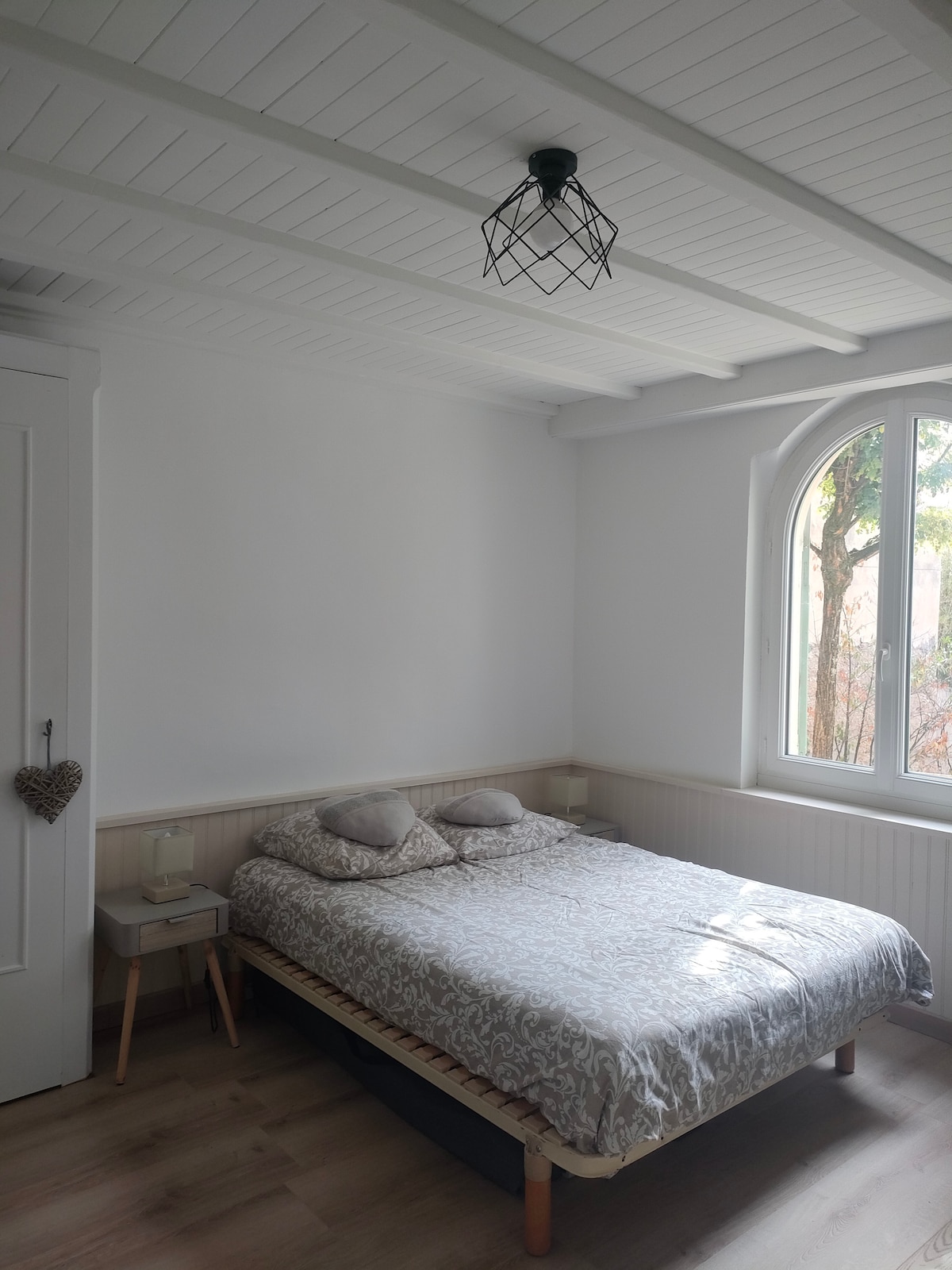 Spavaća soba s bračnim krevetom i vrtnim prozorom