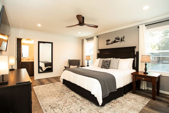 Главна спална соба на највисоко ниво со луксузен брачен кревет и со 50-инчен паметен телевизор монтиран на ѕид