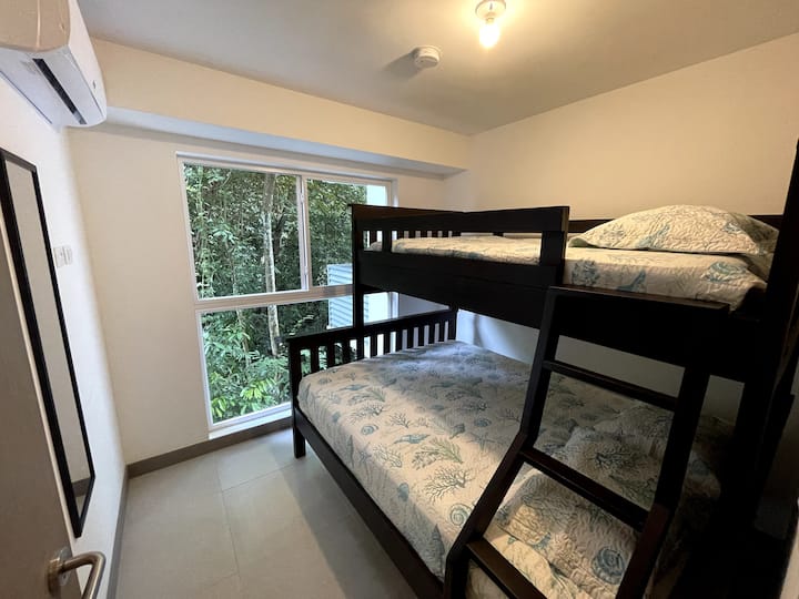 Spálňa pre hostí s poschodovou posteľou, spodná posteľ je veľká a horná je samostatná posteľ. 