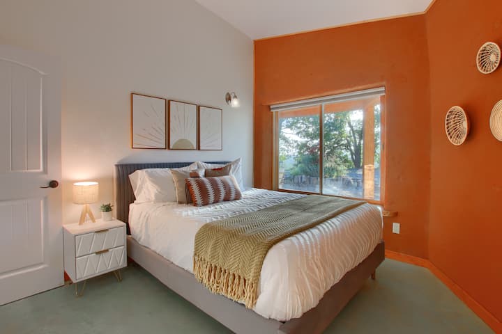 Спалня №3 с двойно легло с спокойна гледка към градината през прозореца.