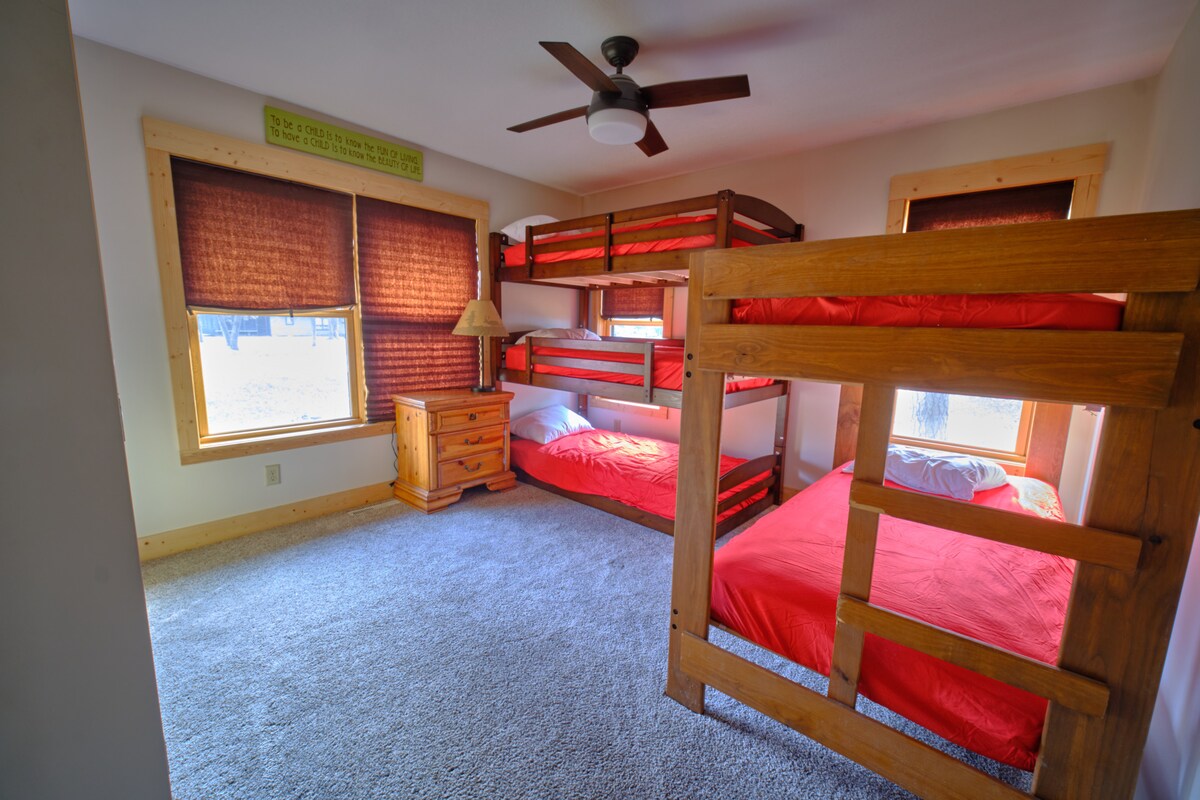 חדר שינה שני בקומה הראשונה עם מיטה זוגית ומיטת קומותיים משולשת. מזרן זוגי נוסף זמין מתחת למיטה זוגית לשינה נוספת במידת הצורך. מושלם לילדים!