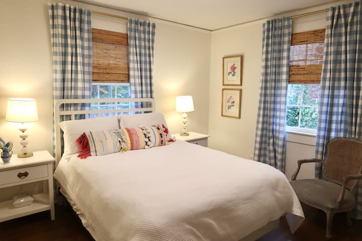 Lit queen size avec deux tables de chevet, commode et placard.