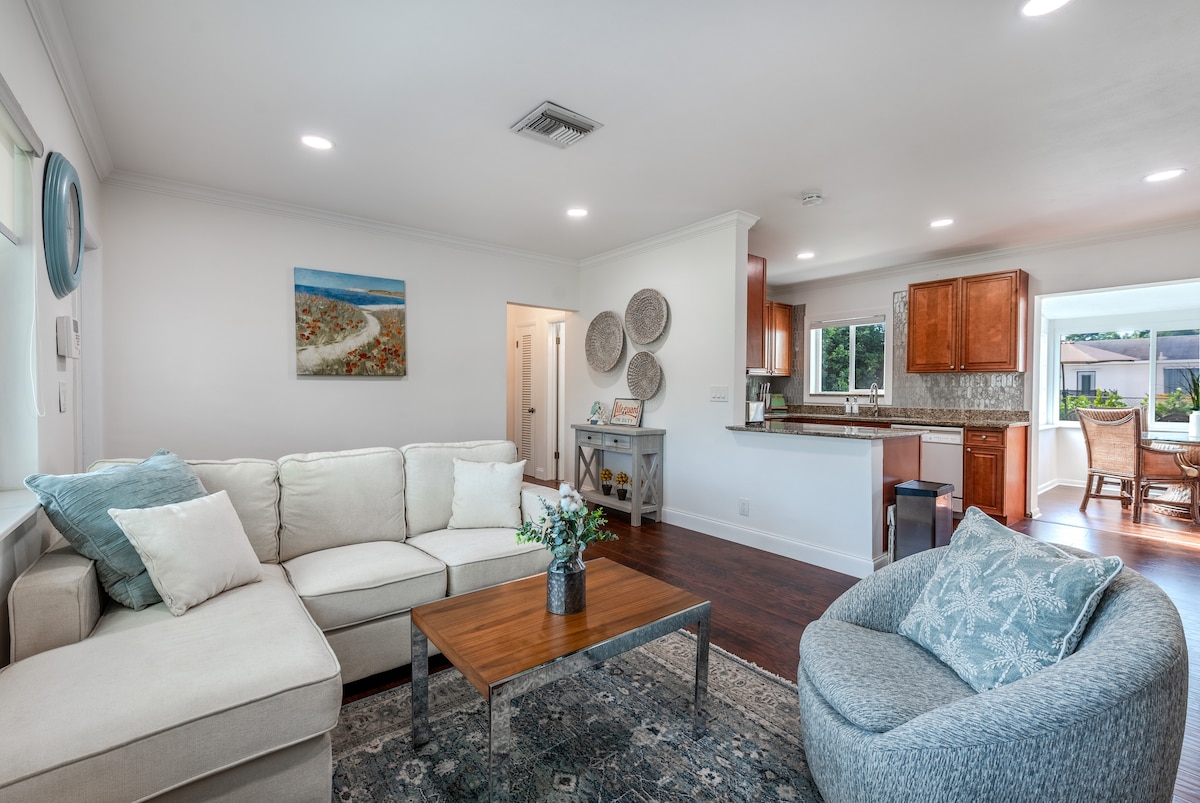 Cozy, sunlit living room with 4K Smart TV, stylish décor, plush seating, and perfect for relaxing stays.