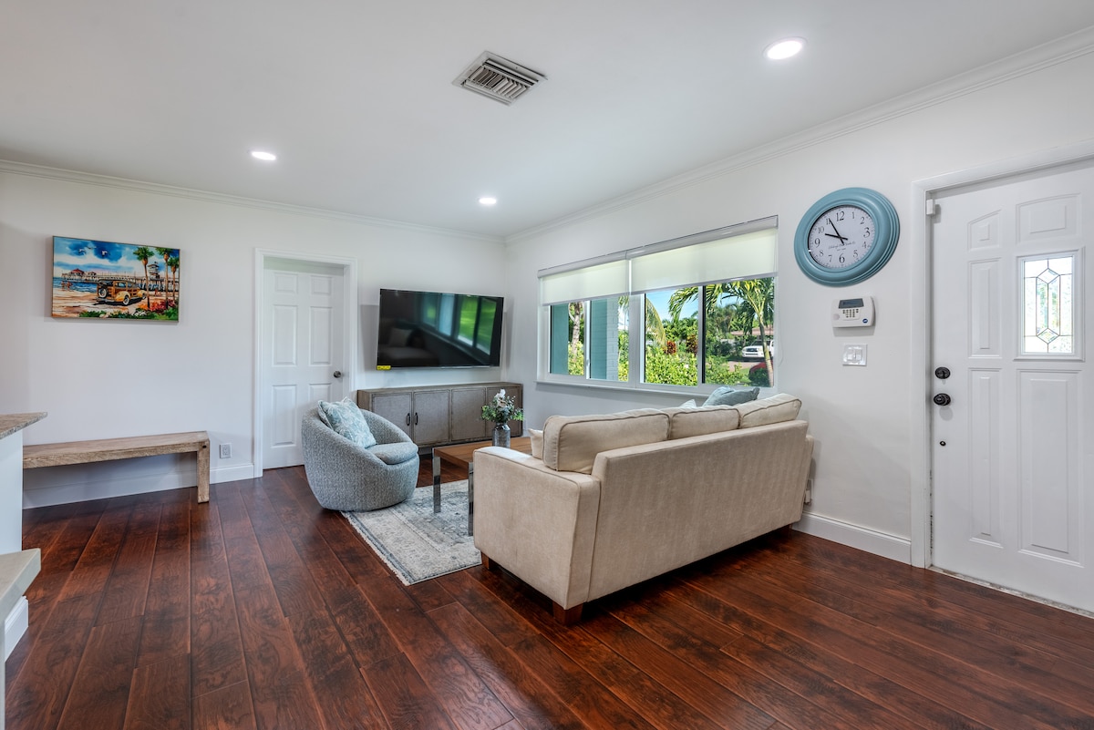 Cozy, sunlit living room with 4K Smart TV, stylish décor, plush seating, and perfect for relaxing stays.