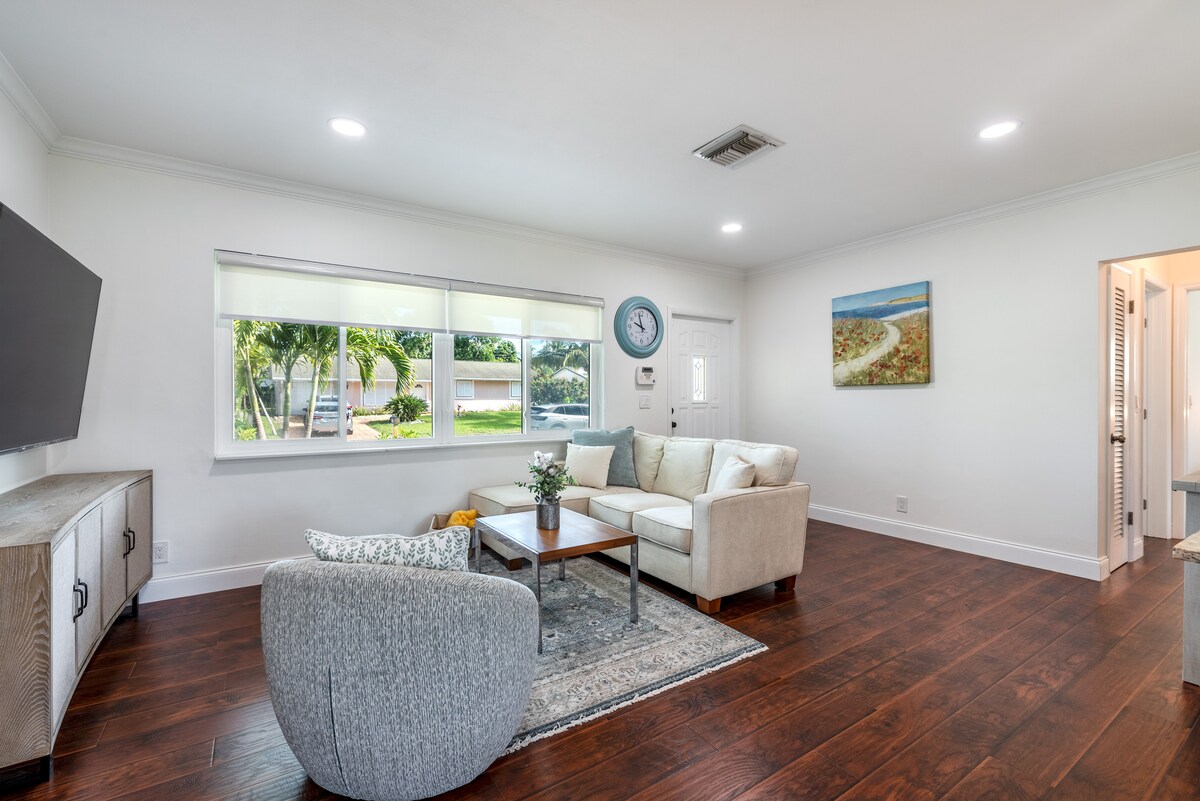 Cozy, sunlit living room with 4K Smart TV, stylish décor, plush seating, and perfect for relaxing stays.