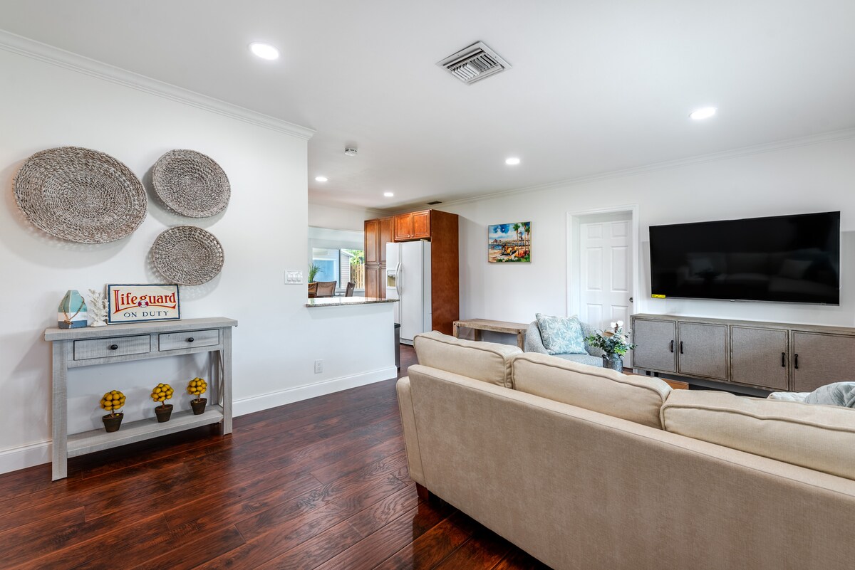 Cozy, sunlit living room with 4K Smart TV, stylish décor, plush seating, and perfect for relaxing stays.