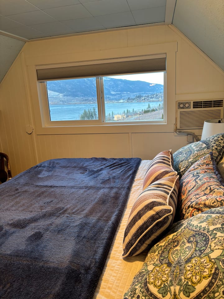 Deuxième chambre avec lit King Size, lit pour bébé et vue sur deux lacs de l'Okanagan.