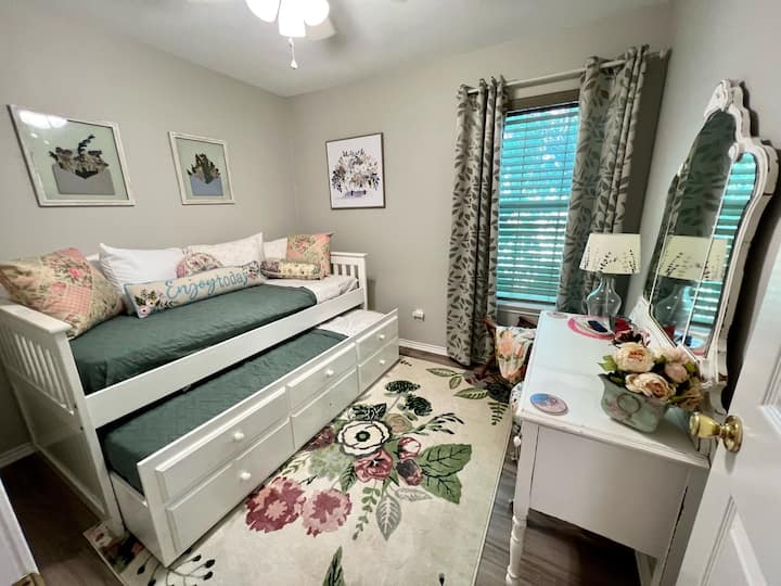 Middle bedroom with trundle bed. Black out curtains, tv and dresser.