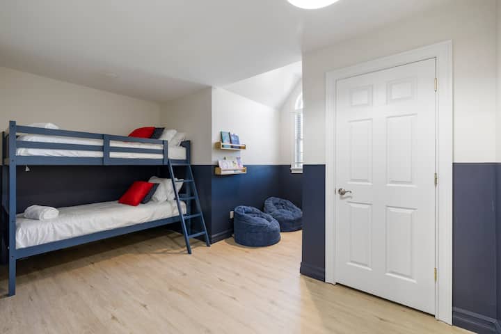 Ფართო საძინებელი ლუქს-კლასის 7-საძინებლიან საცხოვრებელში ჩესტერში, რომელშიც დგას ორი კომფორტული ორსართულიანი საწოლი და ორი პლუშის სკამი, რომელიც იდეალურია დასვენებისთვის.