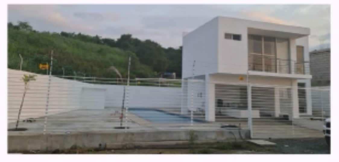 An elegant modern house is displayed, featuring a two-story design with expansive glass doors. A large swimming pool is seen in the foreground, accompanied by a secure, fenced outdoor area. Lush greenery is visible in the background, adding to the serene atmosphere.