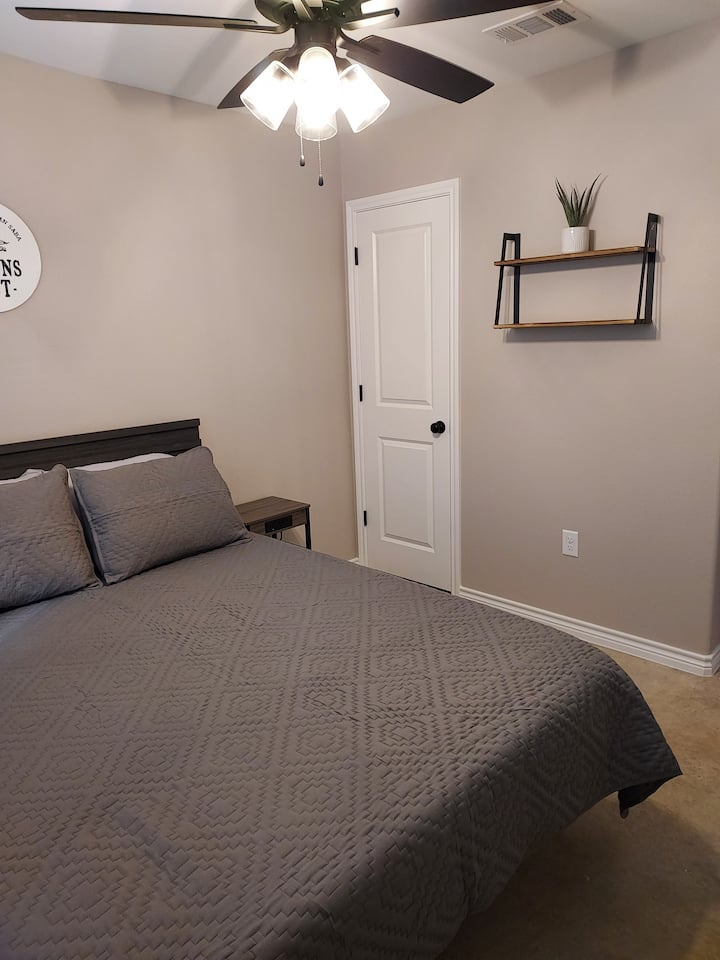 El dormitorio principal tiene un armario, estanterías y 2 mesitas de noche para el almacenamiento y la comodidad.