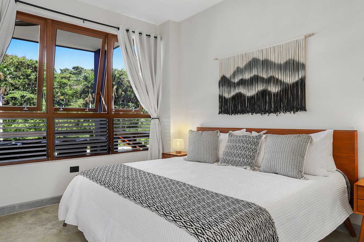 Habitación #1 con una cama tamaño king y vistas directas a la terraza y al bosque.