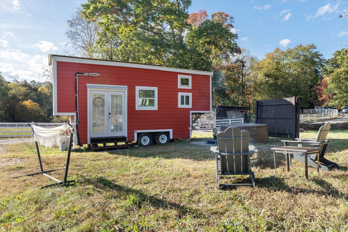 Big Red tiny home exterior with Adirondack chairs and hot tub
