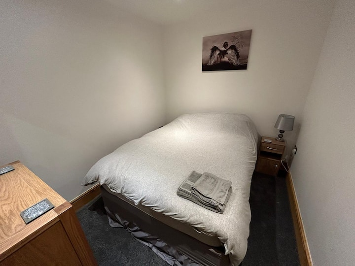 Dormitorio 1 Cama doble, ropa de cama, cómoda, pequeña barra extraíble para colgar, espejo, mesa auxiliar y lámpara, calentador, secador de pelo.