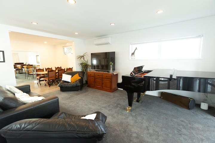 La sala de entretenimiento tiene asientos más cómodos, un televisor inteligente de alta definición de 65 pulgadas y un nuevo piano de cámara alemán: el superior Schimmel K230 Konzert. El alojamiento es muy apreciado por los músicos profesionales. Ten en cuenta los dos comedores en el fondo.