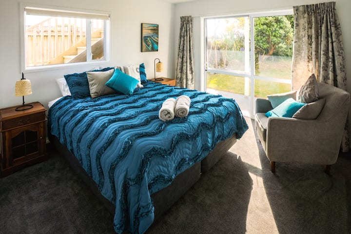 En la planta baja, la habitación del Océano Austral tiene una cama tamaño king y controles deslizantes del rancho que se abren al jardín junto al mar. 