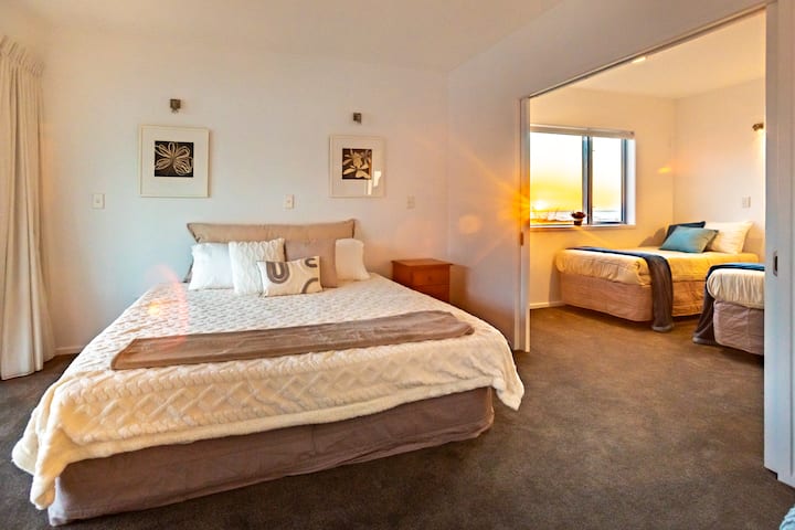 Una cama tamaño king para un sueño espacioso, junto a la habitación doble de arriba.  Casi todas las salas de estar y dormitorios se abren a las terrazas de arriba y a los patios cubiertos de abajo. Esta habitación tiene un sol brillante por la mañana y puertas francesas dobles hacia una terraza de arriba. 