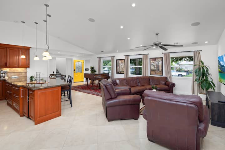 The room boasts an open concept design, allowing for a free flow of energy and light throughout. High ceilings and large windows create an airy and expansive atmosphere, filling the room with an abundance of natural light.