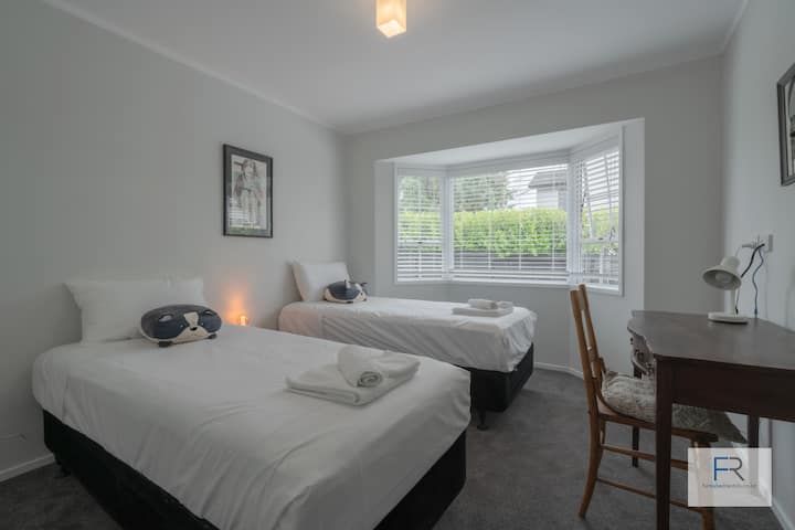 Zweibettzimmer mit  Einzelbetten und Schreibtisch.