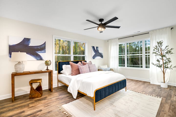 Experimenta el epítome de la comodidad en este dormitorio con una espaciosa cama tamaño king adornada con ropa de cama de felpa, complementada con la suave brisa de un ventilador de techo y luz natural que fluye a través de elegantes ventanas.