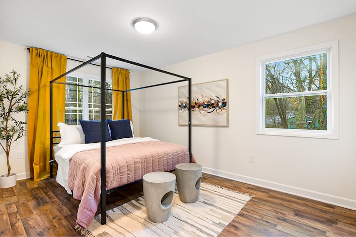 Deléitate con la opulencia en esta habitación, con una majestuosa cama tamaño king con dosel enmarcada por ventanas vestidas con elegantes cortinas.