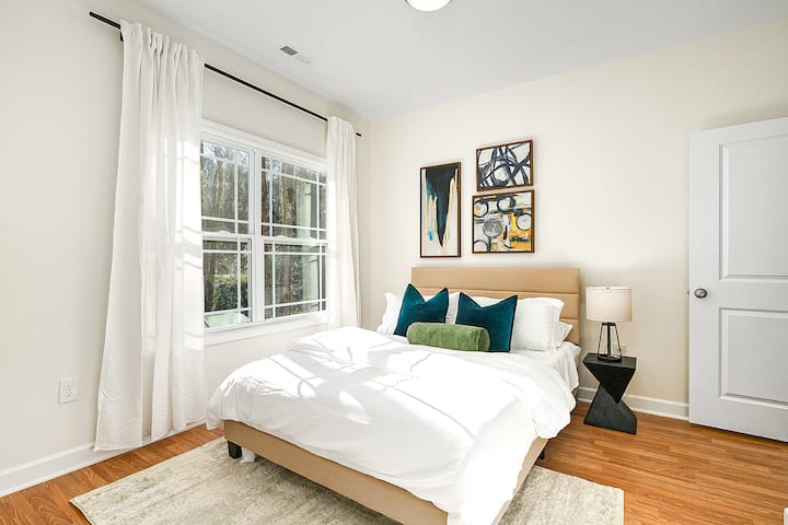 Relájate en este relajante dormitorio adornado con marcos para colgar que agregan un toque personalizado.