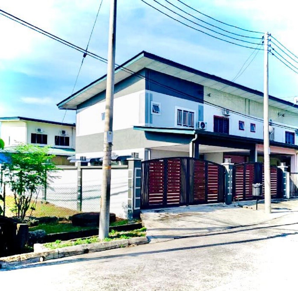 The exterior of a two-story property is presented, featuring a modern design with a combination of light and dark color tones. A gated entrance is visible, along with a driveway that leads to the house, surrounded by a well-maintained yard.