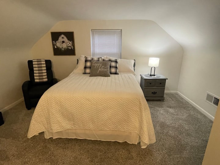 Schlafzimmer im Obergeschoss - Doppelbett & TV. Schreibtischbereich und ein Liegestuhl.