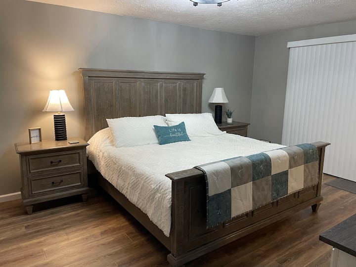 Hauptschlafzimmer -  Kingsize-Bett & TV auf der 1. Etage. Glasschiebetüren öffnen sich zu einer kleinen Terrasse und einem Blick auf den Außenbereich.