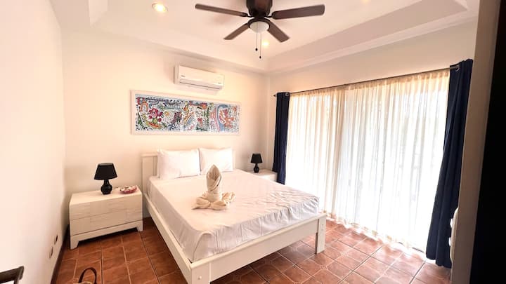 Dormitorio con cama tamaño queen/ Cuarto con cama queen.