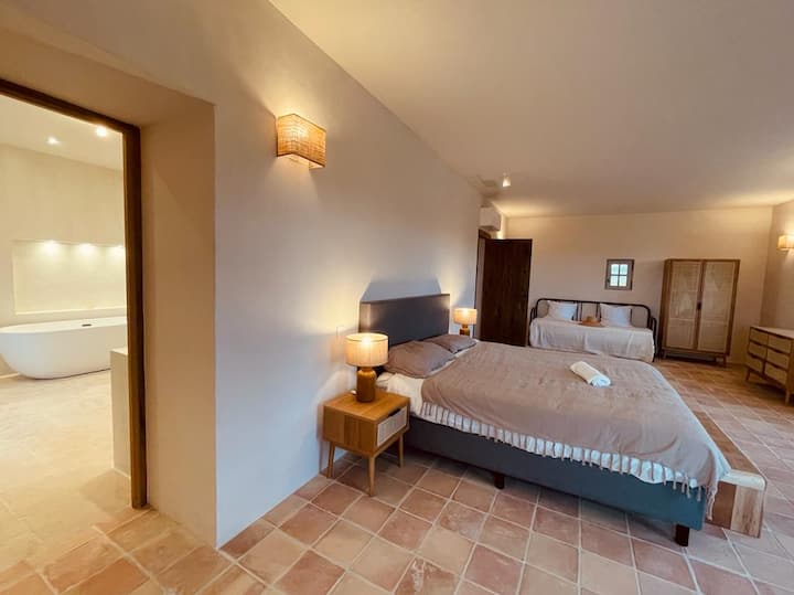 La 6ème chambre se situe au 1er étage dans l'aile Est. Exposé Sud & Est, de larges ouvertures vous permettront d'admirer les jardins, la piscine et les reliefs environnants. Elle dispose de nombreux rangements et sa salle de bain privative.