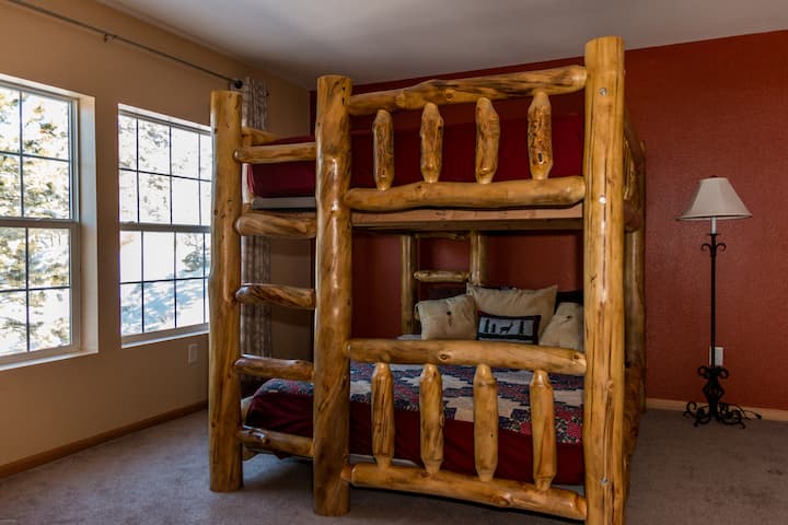 Krevati i sipërm apo i poshtëm? Kjo dhomë gjumi argëtuese me trungje rustike lidhet me banjën e katit kryesor. Një derë ndan dy dhomat për privatësi.