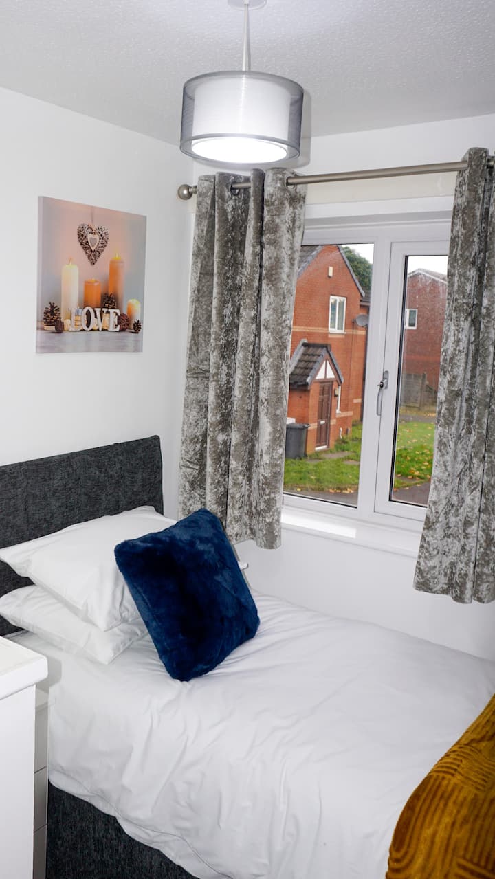 Chambre confortable avec un lit simple confortable, des cintres pour vos vêtements et de l'espace pour vos effets personnels.