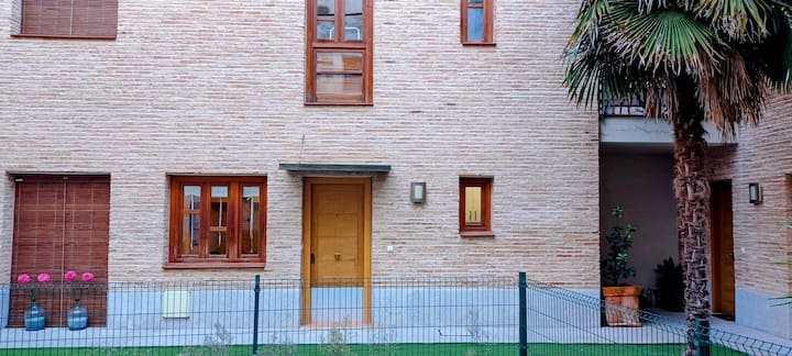 Fachada de ladrillo visto con ventanas de madera: una casa con carácter.