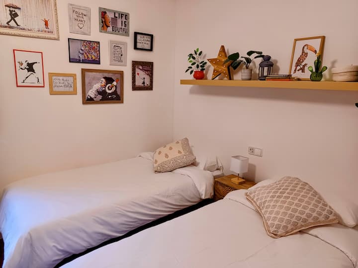 Segundo dormitorio con dos camas individuales y baño privado.