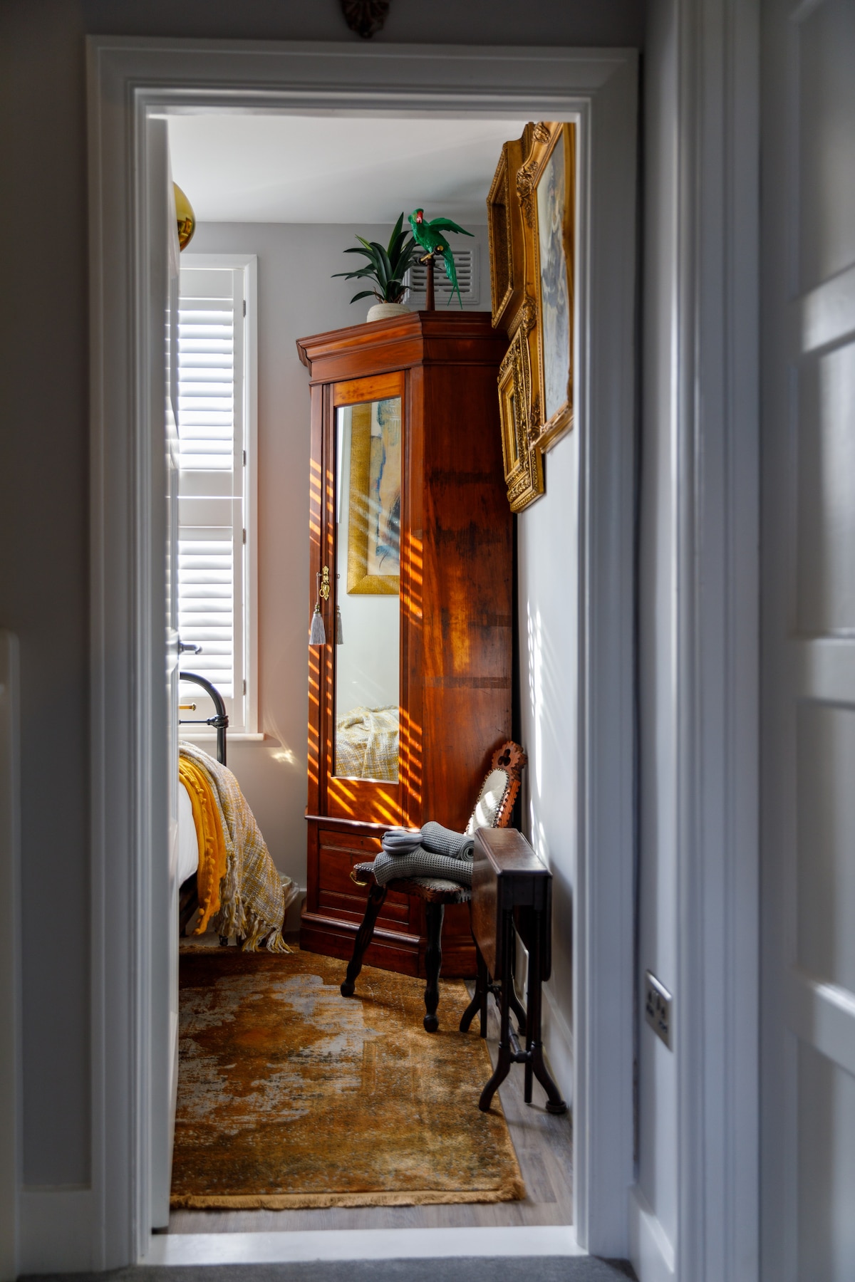 Შესასვლელი ყვითელ საძინებელში, სადაც ნაჩვენებია გარდერობი, პატარა სკამი და პატარა მაგიდა