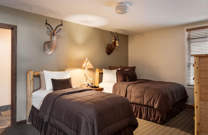 Удобна спална соба со два кревета и елегантен декор.