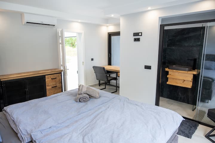 1号卧室，配备三星电视、独立卫生间和独立露台。 书桌可俯瞰海景。