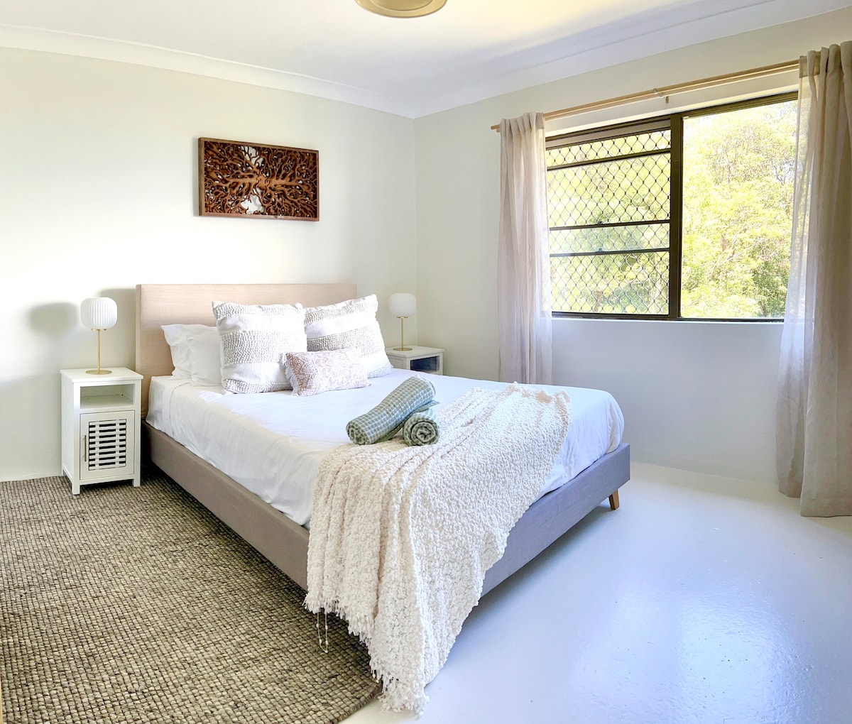 Main bedroom with ocean views from the bed and surrounded by rainforest bushland. Super comfortable luxe Queen bed with high quality sheets for you to enjoy.