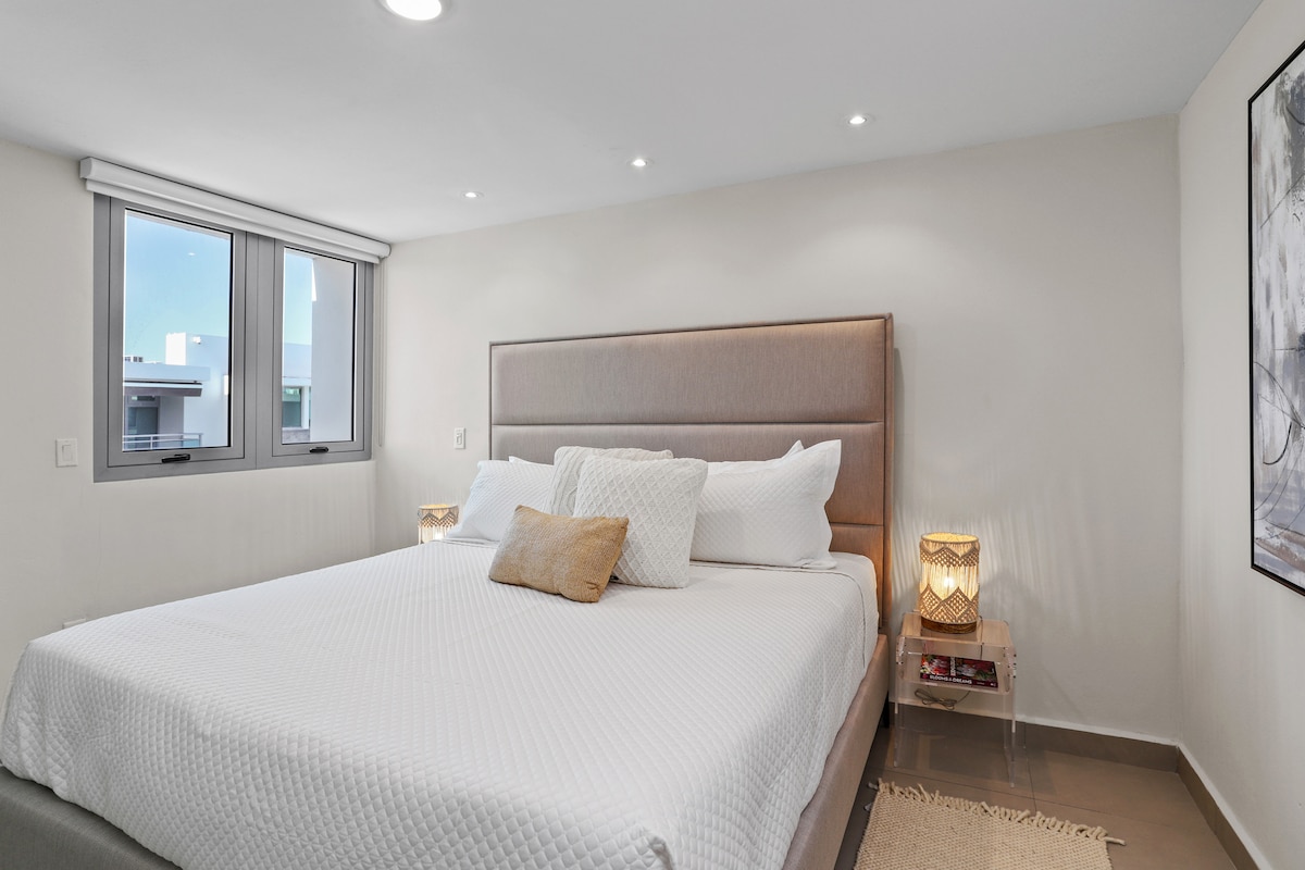 חדר הורים מרווח ומואר היטב עם מיטת קינג סייז, ריהוט מודרני, חדר רחצה צמוד וארון כניסה גדול.