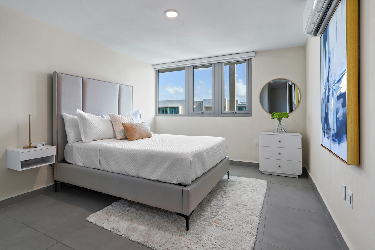 חדר פרופורציונלי היטב עם מיטת קווין סייז, מגירה וארון לאחסון.