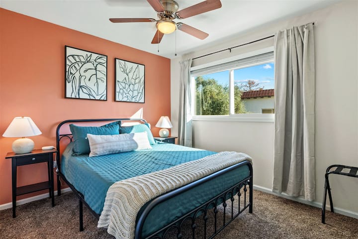 El luminoso y colorido dormitorio queen incluye colcha suave, manta, almohadas, mesita de noche, lámparas, estación de carga y cortinas opacas