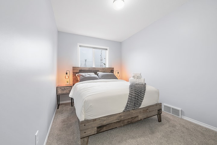 Drift off in comfort with our queen bed, outfitted with fresh, plush bedding and accented by modern dimmable night lamps.