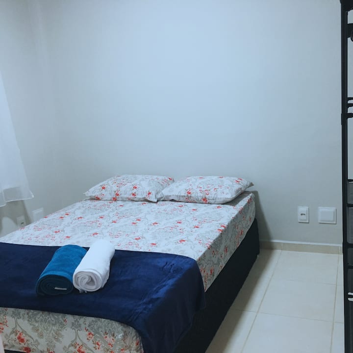 房间有一张双人床和一个风扇，床附近有插座。