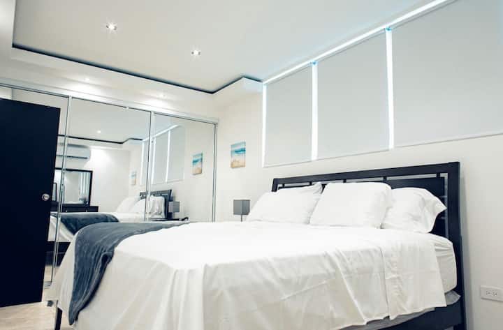 Втора спална соба со телевизор со рамен екран.