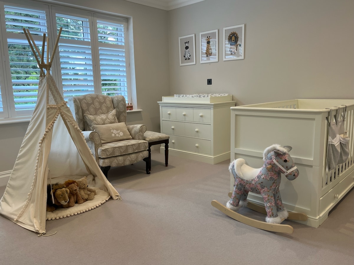 غرفة تستخدم حاليًا كحضانة مع حمام داخلي واسع، ولكنها ستشمل سريرًا بمقاس كبير أثناء الإيجارات ويمكن إزالة سرير الأطفال.